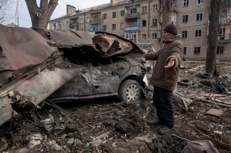 俄軍28日空襲烏東康斯坦丁諾夫卡住宅區，一名居民站在被摧毀的汽車旁。（路透社）