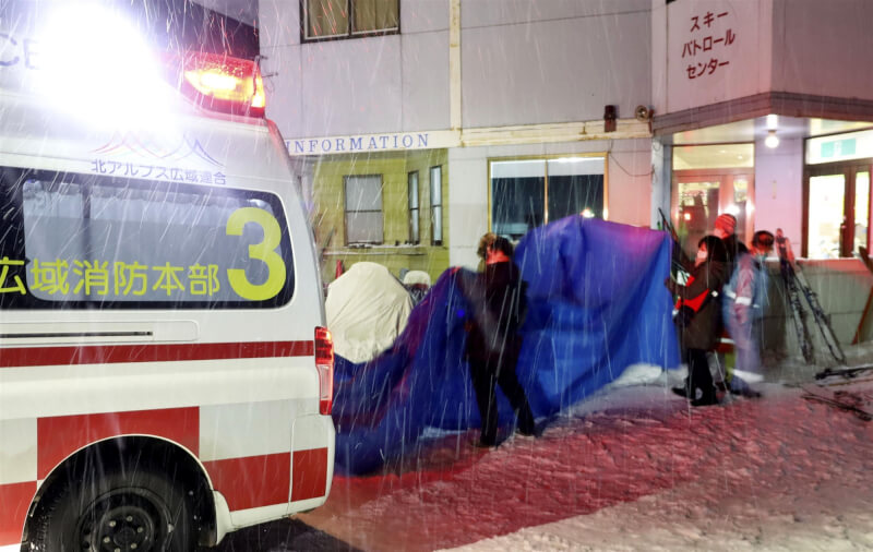 日本中部長野縣海拔約2100公尺的山坡地29日發生雪崩，當地員警30日上午從雪中找到2名男性，但已呈現心肺功能停止的狀態。圖為29日晚間傷者被送上救護車。（共同社）
