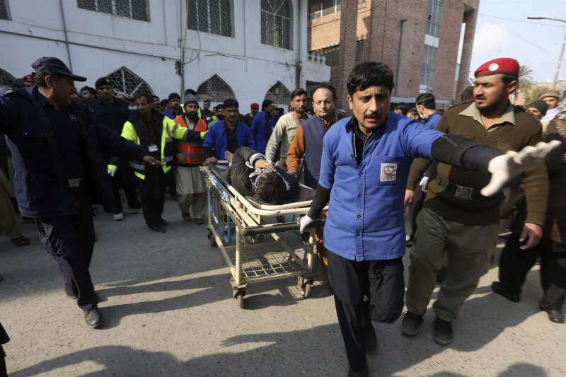 巴基斯坦白夏瓦市一處清真寺30日發生爆炸案，急救人員協助運送傷患。（美聯社）