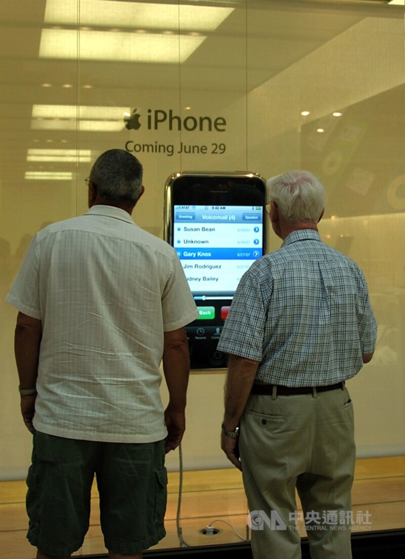 图为2007年苹果旗舰店第一代iPhone上市前橱窗宣传吸引路人驻足。（中央社档案照片）