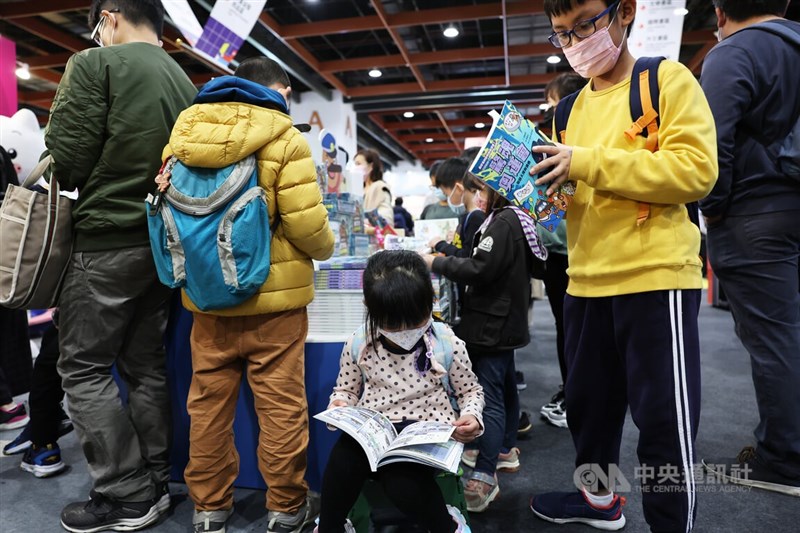 许多家长4日一早就带著孩子到台北国际书展，孩子们捧著喜欢的书，或坐或站地读著。中央社记者赵世勋摄 112年2月4日
