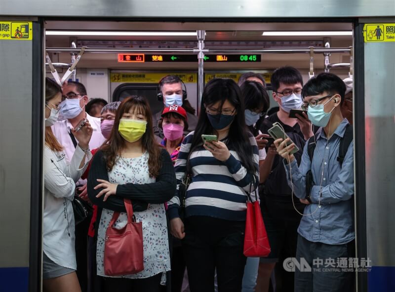 圖為台北捷運民權西路站，民眾進入車廂皆配戴口罩。（中央社檔案照片）