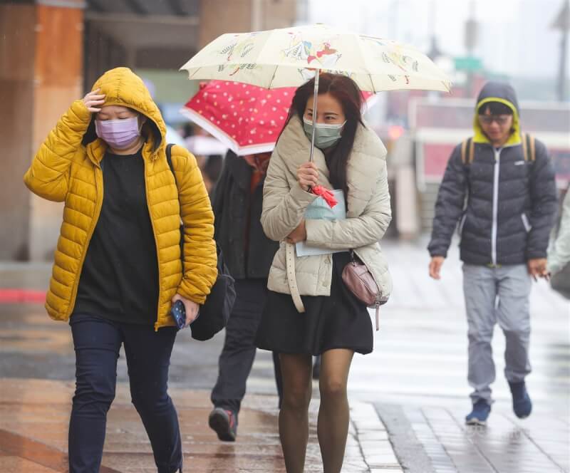 氣象局表示，13日傍晚起冷空氣影響，預估持續至16日，西半部平地低溫可降至攝氏9度左右。圖為台北市中正區街頭民眾撐傘擋雨。（中央社檔案照片）