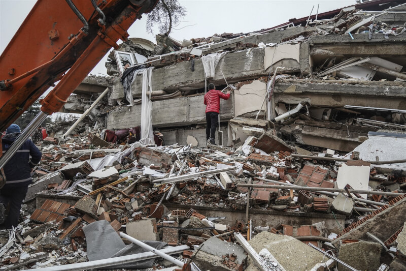 土耳其東南部城市加濟安泰普一棟多樓層建物遭6日強震夷平，民眾試圖在斷垣殘壁中找尋生還者。（美聯社）