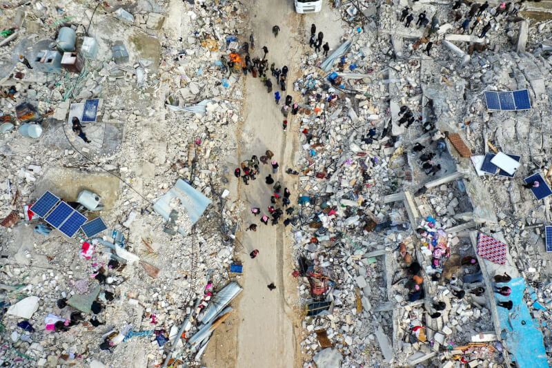 圖為敘利亞伊德利布省一處村落多棟建物倒塌，居民們在瓦礫堆中尋找生還者及罹難者。（法新社）