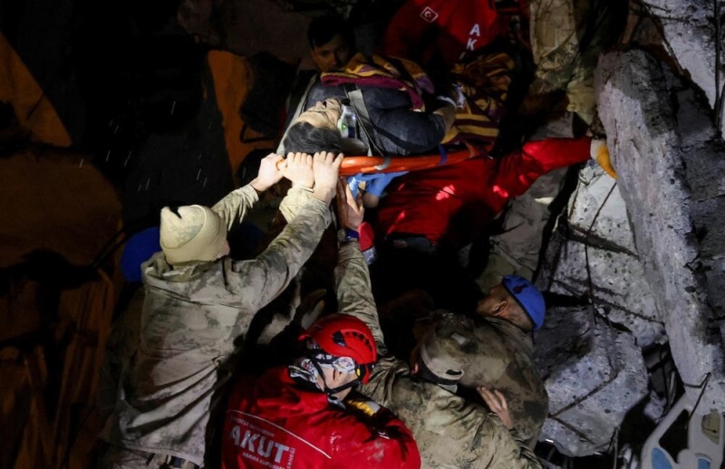 土耳其伊斯肯德隆港救援人員6日將受困者從受損建物中抱出。（路透社）