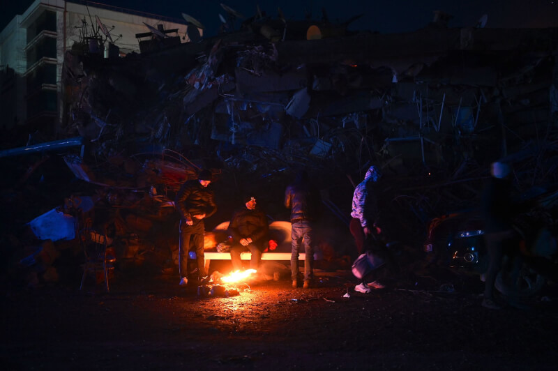 土耳其和敘利亞強震罹難人數已逾7800人。圖為卡拉曼馬拉斯省災民7日在街頭燒垃圾碎片取暖。（法新社）