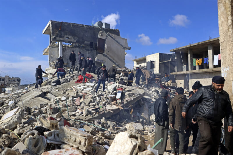 圖為6日敘利亞居民在瓦礫堆中尋找倖存者。（法新社）