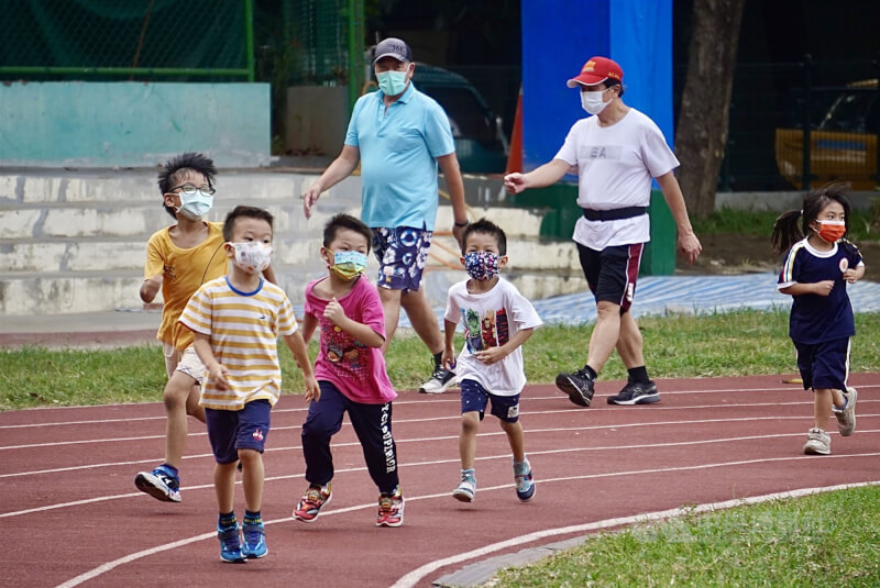 圖為民眾帶孩童在高雄市三民區一處校園操場內運動。（中央社檔案照片）