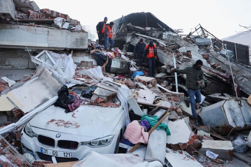 圖為土耳其重災區哈泰省民眾9日在斷垣殘壁中尋找生還者。（路透社）