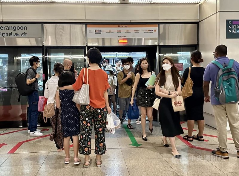 新加坡13日起進一步鬆綁室內口罩令，搭乘地鐵、公車等大眾運輸工具不再強制戴口罩；新措施上路首日，多數民眾仍選擇繼續戴。圖為當地地鐵站的人群。中央社記者侯姿瑩新加坡攝  112年2月13日