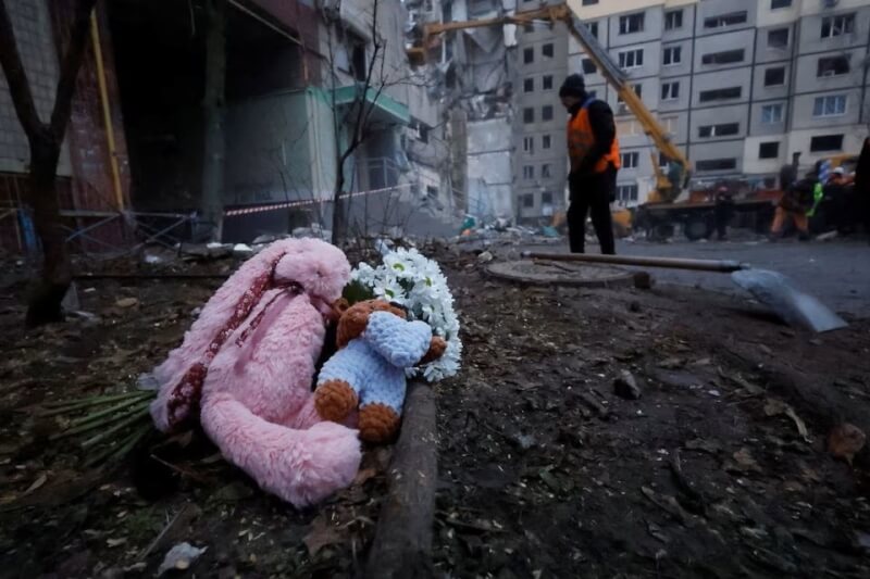 烏克蘭第聶伯羅一棟公寓1月遭俄軍砲擊成為廢墟，有民眾在公寓前放置玩偶悼念。（路透社）