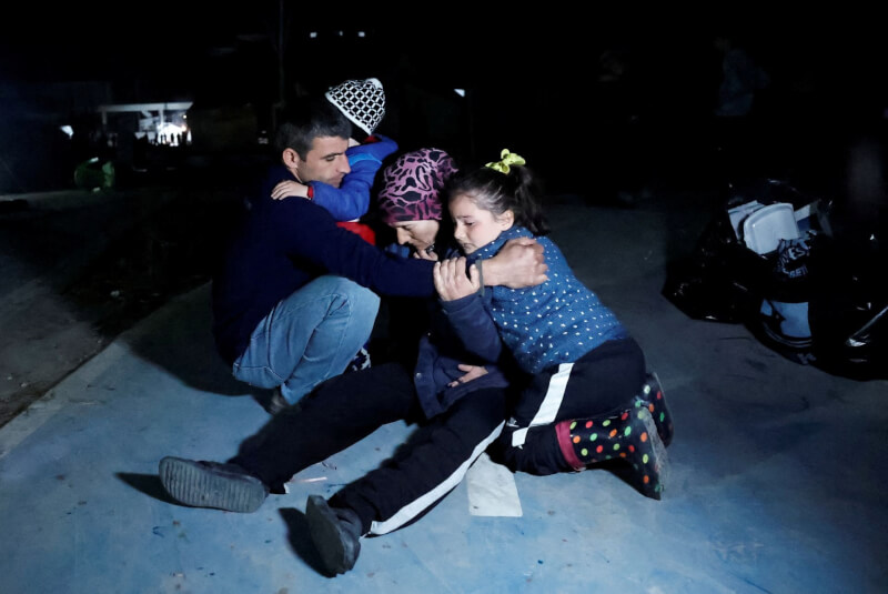 20日地震發生後，一家人緊緊抱在一起。（路透社）