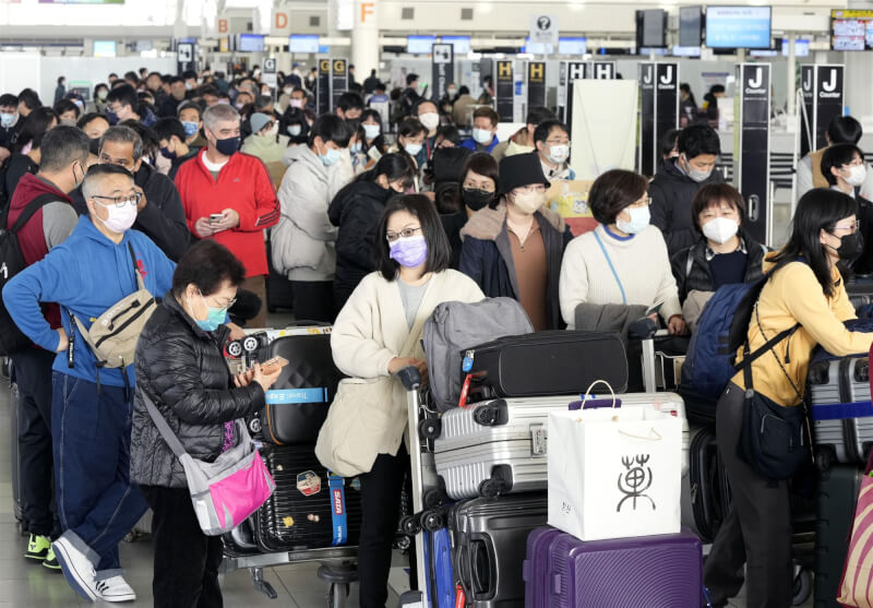 圖為日本福岡機場8日國際航站擠滿乘客。（共同社）