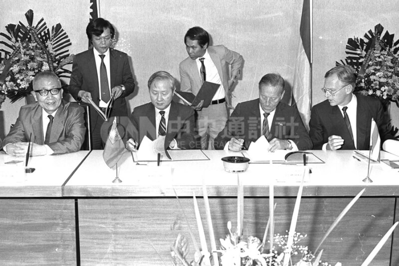 1986年6月9日台灣推動超大型積體電路設廠計畫，時任工研院院長張忠謀（前排左2）與荷蘭飛利浦公司總裁范戴克（Van Der Klugt）（右2）簽約。（中央社檔案照片）