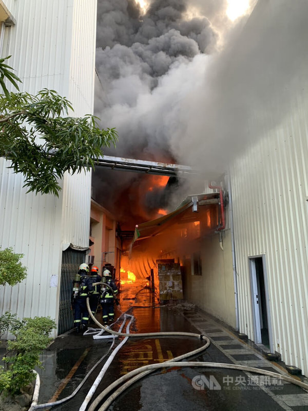 台中市霧峰區一處食品容器工廠23日上午發生火警，因燃燒場內紙箱，火勢一發不可收拾，消防人員布水線搶救。（翻攝照片）中央社記者蘇木春傳真  112年2月23日