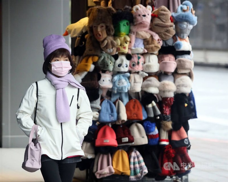 強烈大陸冷氣團影響，中部以北天氣寒冷。圖為台北市南區外出民眾戴毛帽、圍巾禦寒。（中央社檔案照片）