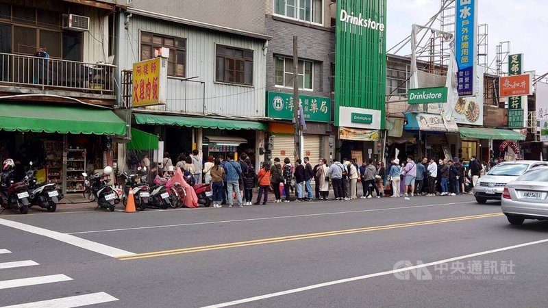 228連假各地湧現出遊人潮，嘉義市區26日著名的火雞肉飯店家門口都大排長龍。圖為吳鳳北路上民眾排隊等待購買火雞肉飯情形。中央社記者蔡智明攝  112年2月26日