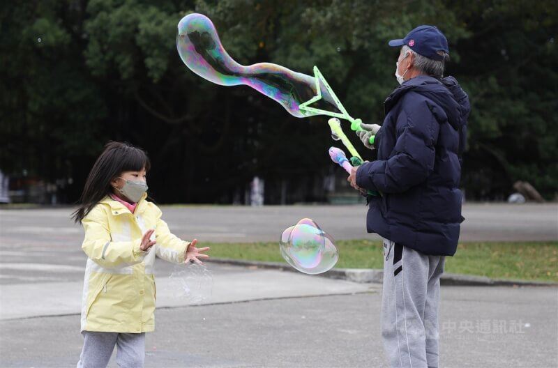 圖為民眾26日在台北華山大草原遊戲場旁玩泡泡。（中央社檔案照片）
