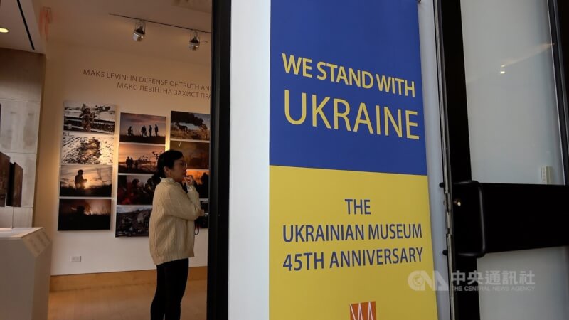 紐約烏克蘭博物館大門旁有「我們與烏克蘭站在一起」的藍、黃底色標語，提醒訪客一年前俄軍全面入侵烏克蘭掀起的戰火尚未止息。中央社記者尹俊傑紐約攝 112年2月27日