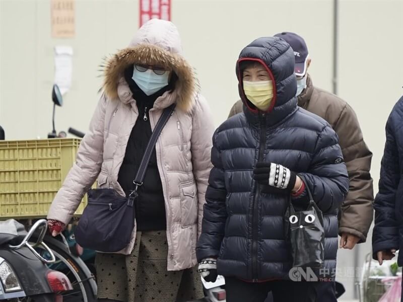 圖為走在台北市北投區街頭的民眾穿上外套禦寒。（中央社檔案照片）