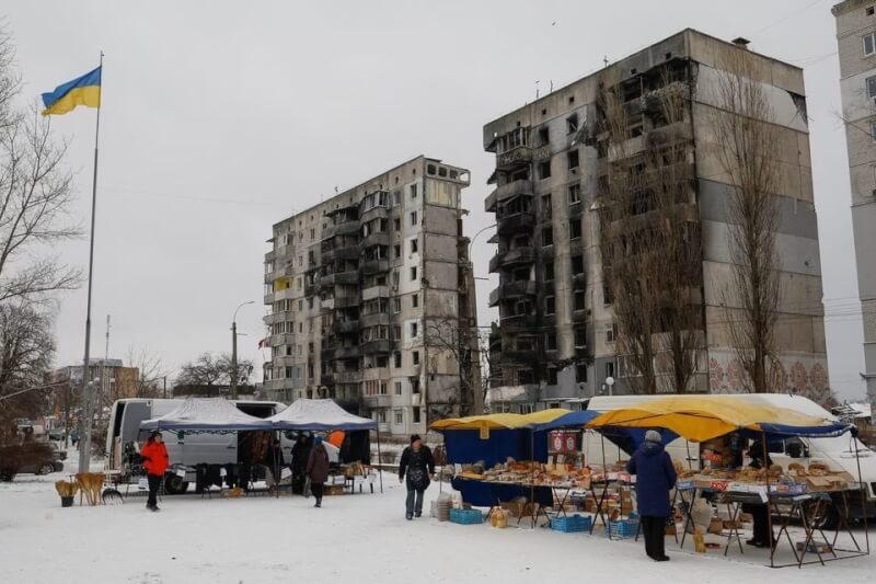 圖為去年12月博羅江卡民眾在被俄軍摧毀的建築前向攤車購買食物。（路透社）