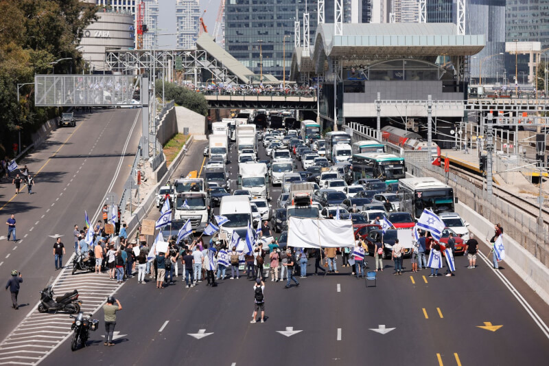 以色列示威民眾1日站在馬路上阻擋車輛行進。（路透社）