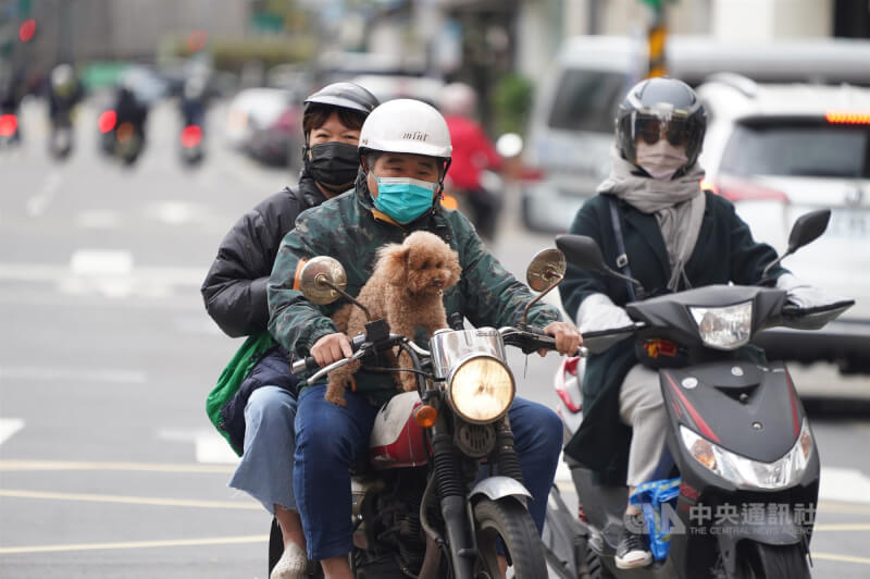 圖為民眾穿外套、戴圍巾騎機車穿梭在台北市大同區街頭。（中央社檔案照片）