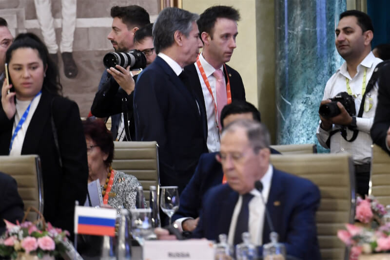美國官員說，國務卿布林肯（後中）2日在20國集團（G20）外交部長會議場邊與俄羅斯外長拉夫羅夫（前右）短暫會晤。（OLIVIER DOULIERY / POOL / 法新社）