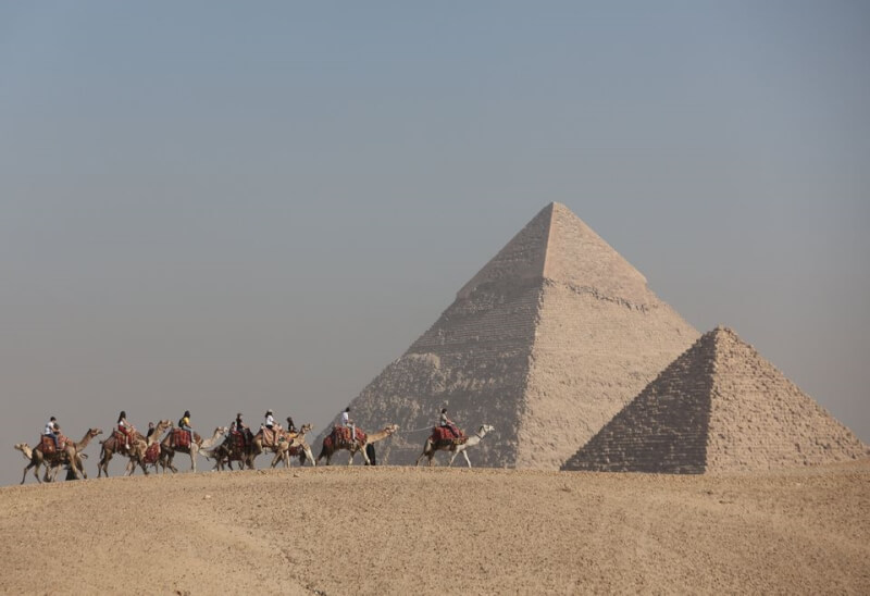 埃及古蹟最高委員會官員2日表示，科學家在吉薩大金字塔主要入口附近偵測到一條密道。圖為遊客騎著駱駝經過吉薩大金字塔。（路透社）
