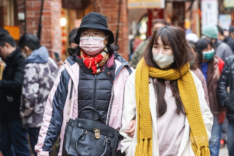 氣象局針對新北至彰化、南投、宜蘭及花蓮等10縣市發布低溫特報。圖為民眾穿上厚外套、圍上圍巾，走在新北市深坑老街。（中央社檔案照片）