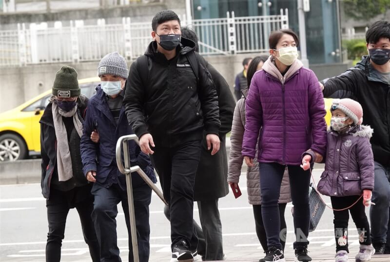 中央氣象局表示，冷氣團預計12日晚間南下。圖為台北市南港區民眾穿外套、戴帽子禦寒。（中央社檔案照片）