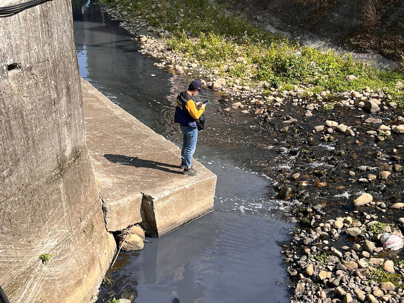 新北市五股坑溪溪水發黑，還有死魚漂浮，環保局獲報前往稽查，追查發現是某金屬表面處理業者的漆料貯存設施故障，導致漆料外溢釀污染。（新北市環保局提供）中央社記者高華謙傳真  112年3月10日