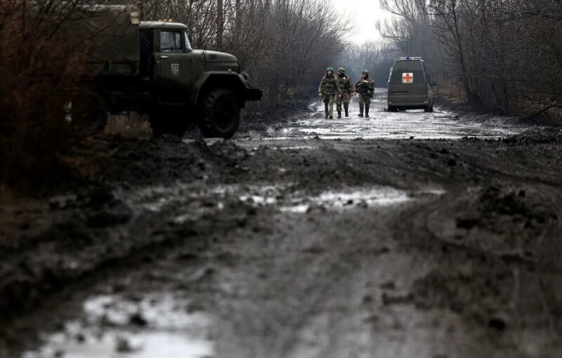 烏克蘭軍人8日沿著東部城市巴赫姆特附近的泥濘道路行走。（路透社）