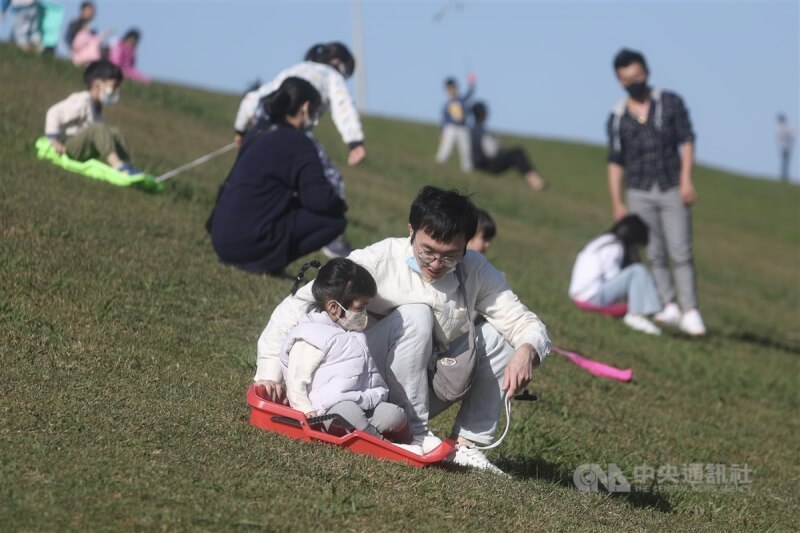圖為5日八里十三行文化公園內民眾在陽光下體驗滑草。（中央社檔案照片）