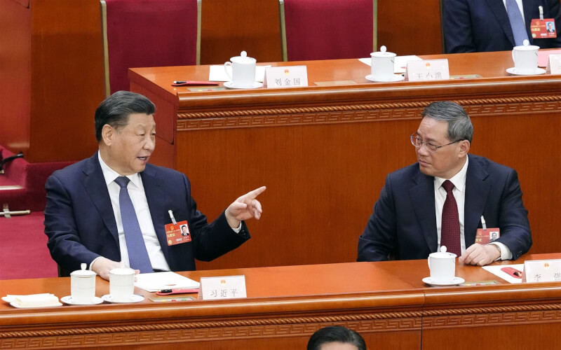 圖為中國國家主席習近平（左）11日在人大會議中與李強（右）交談。（共同社）