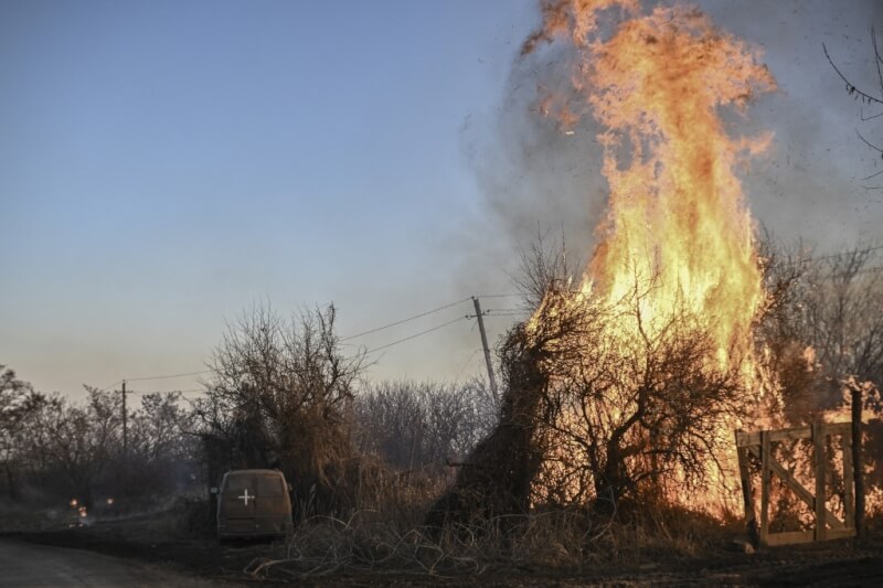 烏克蘭東部查西夫雅爾鎮遭白磷彈攻擊，白磷彈藥在空中爆炸後，烏克蘭軍車（車身有白十字標誌）旁邊的樹木被燒毀。（法新社）