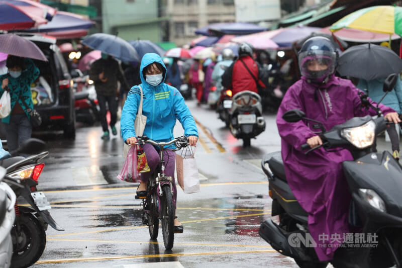 圖為民眾穿雨衣撐傘到新北蘆洲一處傳統市場。（中央社檔案照片）