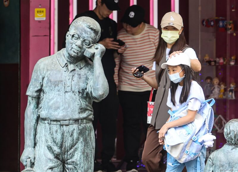 中央流行疫情指揮中心20日公布新增5411例本土病例。圖為台北市大同區，部分民眾外出還是會戴上口罩。（中央社檔案照片）