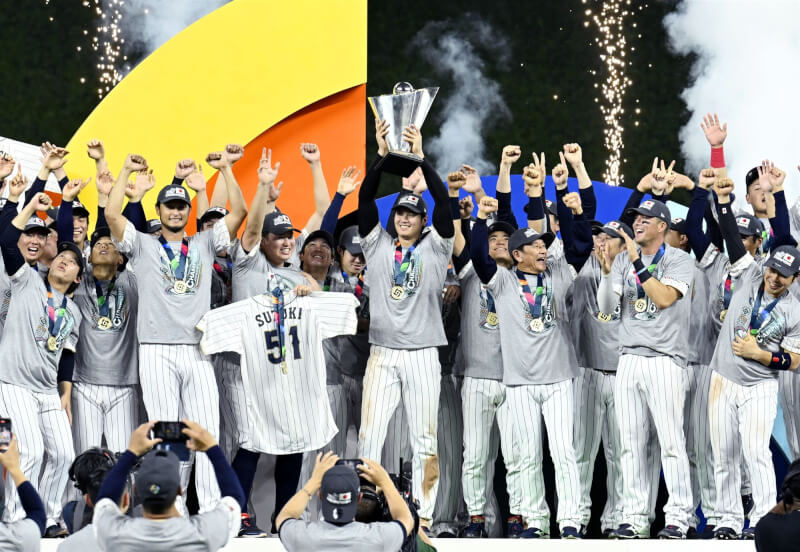 日本隊22日在世界棒球經典賽擊敗美國隊奪隊史第3冠,日本隊監督栗山英樹(第一排右3)與大谷翔平(第一排右4)師徒共譜的「二刀流第2章」,最後成功寫下最棒結局。(共同社)
