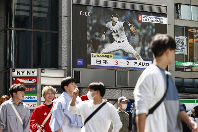第5屆世界棒球經典賽冠軍賽22日落幕，日本朝日電視台進行實況轉播，日本隊奪冠瞬間，關東地區最高家戶收視率高達46.0%。圖為大阪道頓堀電視牆播報經典賽賽況。（共同社）