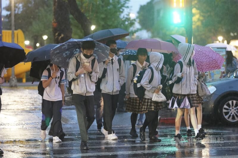 氣象局表示，27日晚至28日晨、30日當天有華南雲雨區影響，主要降雨範圍仍以中部以北、東半部為主。台北市北投區降雨，下課的學生們撐傘遮雨。（中央社檔案照片）
