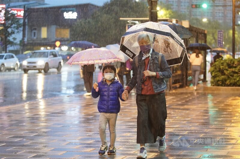 圖為25日北市北投區民眾撐傘避雨。（中央社檔案照片）