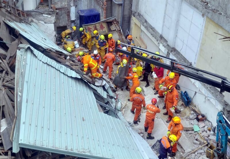 台中市中區台灣大道一段一棟2樓建築物30日倒塌，3工人受困，消防人員到場救援，徒手搬運石塊、鐵皮進行搶救工作。（台中市消防局提供）中央社記者郝雪卿傳真 112年3月30日