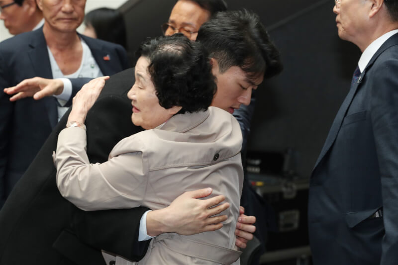 韓國前總統全斗煥的孫子全宇元（前左）3月31日與518光州事件受害者家屬擁抱。（韓聯社）
