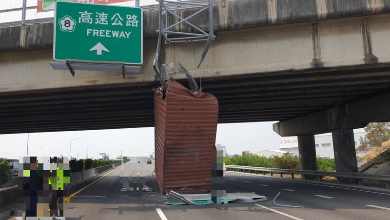 一輛半聯結貨櫃車4日途經國道1號台南麻豆路段時，貨櫃不明原因彈起撞擊上方標誌牌面而卡在跨越橋及中線車道間，幸無人受傷。（國道公路警察局第四警察大隊提供）中央社記者張榮祥台南傳真 112年4月4日