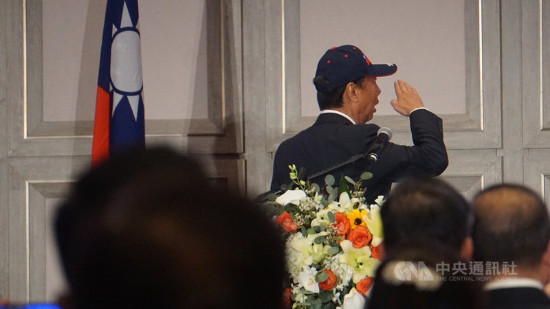 鴻海集團創辦人郭台銘美西時間3日晚上在洛杉磯演講,演講一開頭他邀全場唱美國國歌及中華民國國歌。照片可見他開口唱歌,向國旗行舉手禮。中央社記者林宏翰洛杉磯攝 112年4月4日