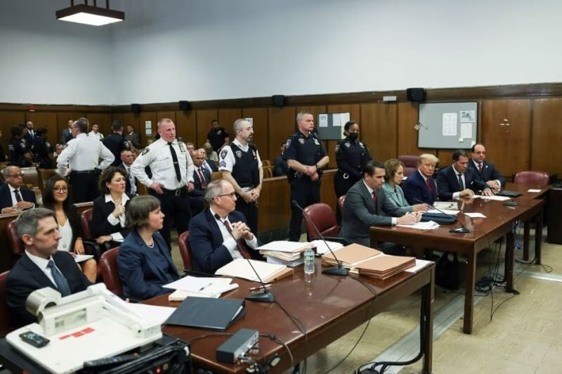 美國前總統川普（前右3）4日出庭面對歷史性刑事起訴，他對封口費案調查衍生的34項偽造商業紀錄重罪指控概不認罪。（路透社）