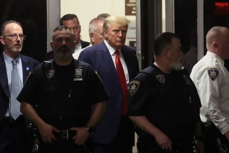 美國前總統川普（左3）4日抵達紐約曼哈頓法院，他為封口費案出庭面對歷史性刑事起訴。（路透社）