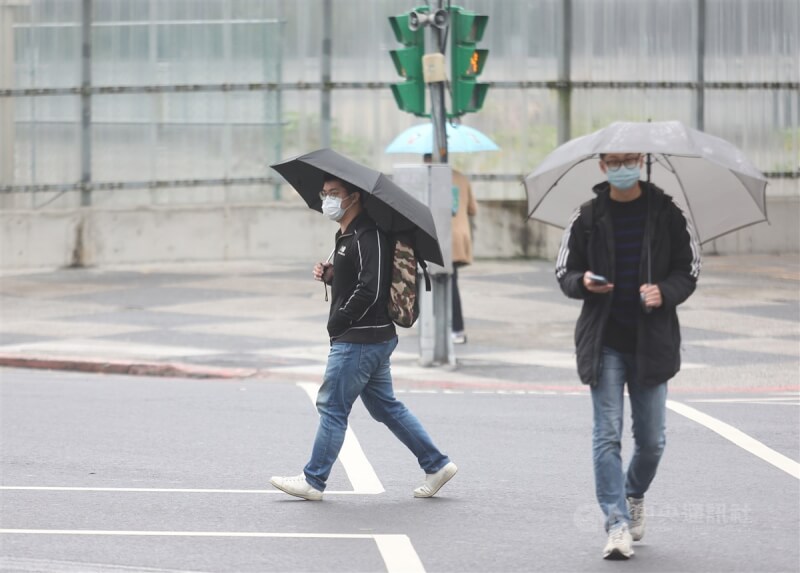 中央氣象局表示，7日鋒面通過、東北季風增強，北部、東半部及中南部山區留意局部短暫陣雨。圖為台北市信義區民眾撐傘遮擋雨勢。（中央社檔案照片）